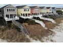 Colorful beach houses line the coast, each with private decks and stairs to the sandy shore at 2000 N Waccamaw Dr., Garden City Beach, SC 29576