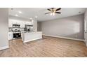 Modern kitchen featuring stainless steel appliances, granite counters, and stylish wood flooring in an open layout at 344 Kiskadee Loop # E, Conway, SC 29526