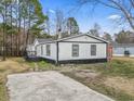 Charming one-story home with black and white exterior, a deck, and a concrete driveway at 3530 Reavis Ln., Myrtle Beach, SC 29579