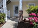 Charming entrance with a brick pillar, wreath on the door, and colorful flowers adds a welcoming touch at 4221 Hibiscus Dr. # 101, Little River, SC 29566