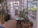 Bright sunroom with many windows, indoor plants, and decorative stained glass offers a peaceful retreat at 4221 Hibiscus Dr. # 101, Little River, SC 29566