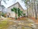 Condo building exterior with palm trees shows unit entrance and natural landscaping at 6840 Blue Heron Blvd. # 108, Myrtle Beach, SC 29588