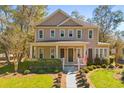 Charming two-story home boasts a welcoming front porch and manicured landscaping, complete with the American flag at 9100 Sw Fountain St., Calabash, NC 28467