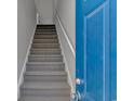 Carpeted staircase with white railing adjacent to a blue front door, providing access to the upper level at 110 Horizon River Dr. # I-2, Myrtle Beach, SC 29588