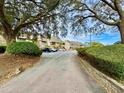 Scenic driveway lined with lush greenery leading to a well-maintained condo complex with ample parking at 1356 Glenns Bay Rd. # 202B, Surfside Beach, SC 29575