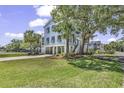 Inviting raised beach home with landscaped yard and covered parking, shaded by mature trees at 1519 N Palmetto Dr., Surfside Beach, SC 29575