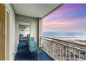 Relax on this balcony with views of the beach, equipped with seating for tranquil moments at 1581 S Waccamaw Dr. # 402, Garden City Beach, SC 29576