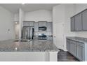 Spacious kitchen featuring granite countertops, gray cabinets, stainless steel appliances, and wood floors at 205 Kinross Ct., Little River, SC 29566