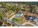 Expansive aerial view of a beautifully landscaped home with a well-manicured lawn and surrounding trees at 208 Green Lake Dr., Myrtle Beach, SC 29572