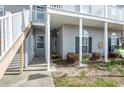 Inviting entrance to the home with covered entry, green landscaping and a white stairway at 220 Portsmith Dr. # 2, Myrtle Beach, SC 29588
