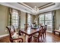 Formal dining room featuring hardwood floors, a chandelier, and large windows with custom curtains at 232 Wahee Pl., Conway, SC 29527