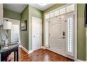 Bright foyer with hardwood floors, a white front door with sidelights, and green walls at 232 Wahee Pl., Conway, SC 29527