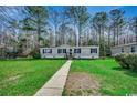 Charming home featuring a well-maintained lawn and a inviting walkway leading to the front door at 24 Majors Ct., Pawleys Island, SC 29585