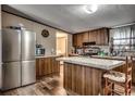 Well-equipped kitchen with stainless steel refrigerator, kitchen island, and wooden cabinets at 24 Majors Ct., Pawleys Island, SC 29585