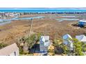 Stunning aerial view of a charming beach house nestled amidst lush marshland, with a pier at 3 Half Shell Ct., Pawleys Island, SC 29585