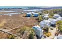 Picturesque aerial view of a serene beach house nestled amidst marshland, near the tranquil ocean at 3 Half Shell Ct., Pawleys Island, SC 29585