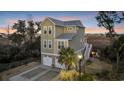 Charming three-story beach house with a two-car garage overlooking a tranquil marsh at sunset at 3 Half Shell Ct., Pawleys Island, SC 29585