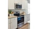 Modern kitchen featuring stainless steel oven and microwave, white cabinets, and granite countertops at 312 Brackish Dr. # 312, Myrtle Beach, SC 29588