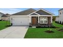 Inviting home with a two-car garage, stone-accented facade, and lush green lawn at 4295 Falls Oaks St., Myrtle Beach, SC 29579