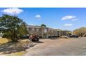 Brick apartment building with well-manicured landscaping and plenty of parking on a sunny day with scattered clouds at 500 Willow Greens Dr. # 500-G, Conway, SC 29526