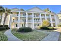 Charming condominium showcasing multi-level balconies, classic columns, and meticulously landscaped surroundings at 5000 Windsor Green Way # 204, Myrtle Beach, SC 29579
