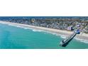 Coastal community aerial view featuring blue water, pier, beach, and colorful houses at 512B S Ocean Blvd., Surfside Beach, SC 29575