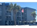 Exterior of building with American flag and palm trees at 6000 N Ocean Blvd. # 122, North Myrtle Beach, SC 29582