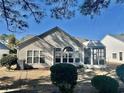 The back exterior shows a screened-in porch and many windows to let in light at 7471 Balmore Dr. Sw, Sunset Beach, NC 28468