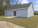 Back exterior view featuring light blue siding and a sliding glass door leading to a concrete patio at 813 Highway 67, Loris, SC 29569