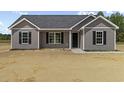 New home construction with gray siding, black door and shutters, and bright white trim on a sunny day at 825 Highway 67, Loris, SC 29569