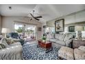 Comfortable living room featuring a large mirror, vaulted ceilings, ceiling fan and large windows with a deck view at 9671 Stillwater Ct., Myrtle Beach, SC 29572