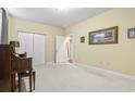 Living room with a piano, carpeted floor, neutral walls, two windows, and a closet at 1033 World Tour Blvd. # 101-A, Myrtle Beach, SC 29579