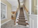 Inviting entryway with tiled floor, coat hooks, and carpeted stairs leading to the main living area at 132 Garden City Retreat Dr., Murrells Inlet, SC 29576