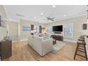 Bright living room featuring hardwood floors, plush sofa, large TV, and natural light at 132 Garden City Retreat Dr., Murrells Inlet, SC 29576