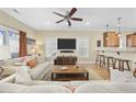 Comfortable living room with ceiling fan, large TV, and breakfast bar overlooking the kitchen at 132 Garden City Retreat Dr., Murrells Inlet, SC 29576