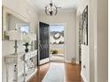 Bright entryway featuring hardwood floors, elegant chandelier, and a view of the front yard through the open door at 1412 Rainsbrook Ct., Conway, SC 29526