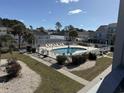 Inviting community pool area, featuring a gated fence, sunbathing chairs, and landscaped surroundings at 1890 Colony Dr. # 17T, Surfside Beach, SC 29575