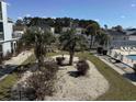 Scenic view of the community pool area, surrounded by lush landscaping and cozy sunbathing chairs at 1890 Colony Dr. # 17T, Surfside Beach, SC 29575