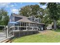 View of backyard with wooden deck, screened in porch and an attractive well-maintained lawn at 316 13Th Ave. N, Surfside Beach, SC 29575