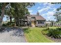 Two-story home with gray siding, chimney, brick-lined gravel driveway, and a bright yellow front door at 316 13Th Ave. N, Surfside Beach, SC 29575