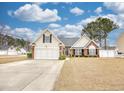 Inviting home with a spacious front yard, a red door, and a two-car garage at 3736 Brookhill Dr., Myrtle Beach, SC 29588