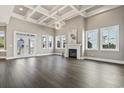 Spacious living room with a coffered ceiling, a modern chandelier, a fireplace, and lots of natural light at 5220 Mount Pleasant Dr., Myrtle Beach, SC 29579