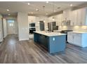 Modern kitchen with stainless appliances, quartz countertops, a kitchen island and pendant lighting at 9021 Aria Way, Longs, SC 29568