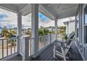 Relaxing covered porch with cozy seating, offering views of the surrounding neighborhood and lush greenery at 1004 Marsh View Dr., North Myrtle Beach, SC 29582