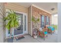 Inviting front porch with wicker seating, decorative plants, and charming brick accents creating a cozy entrance at 110 Echaw Dr., Conway, SC 29526