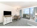 A living room with table and seating next to a sliding glass door with balcony and ocean views at 1105 S Ocean Blvd. # 220, Myrtle Beach, SC 29577