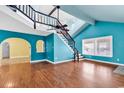 Bright living room features hardwood floors, large windows, and unique staircase and color scheme at 111 S Poplar Dr., Surfside Beach, SC 29575