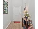 Inviting entryway with hardwood floors, red rug, accent table and golf themed art at 141 Spendor Circle, Murrells Inlet, SC 29576