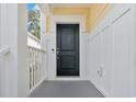 Inviting front door area with black door, grey floor, white trim, and yellow accent wall at 141 Spendor Circle, Murrells Inlet, SC 29576