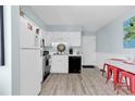 Bright white kitchen with light wood flooring, white appliances and adjacent breakfast table at 1582 S Waccamaw Dr. # 44, Murrells Inlet, SC 29576